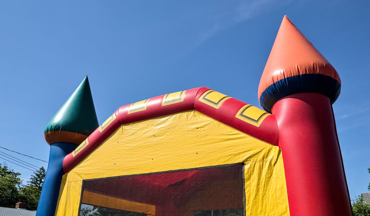 Bouncy castle silhouette against sky for birthday block party