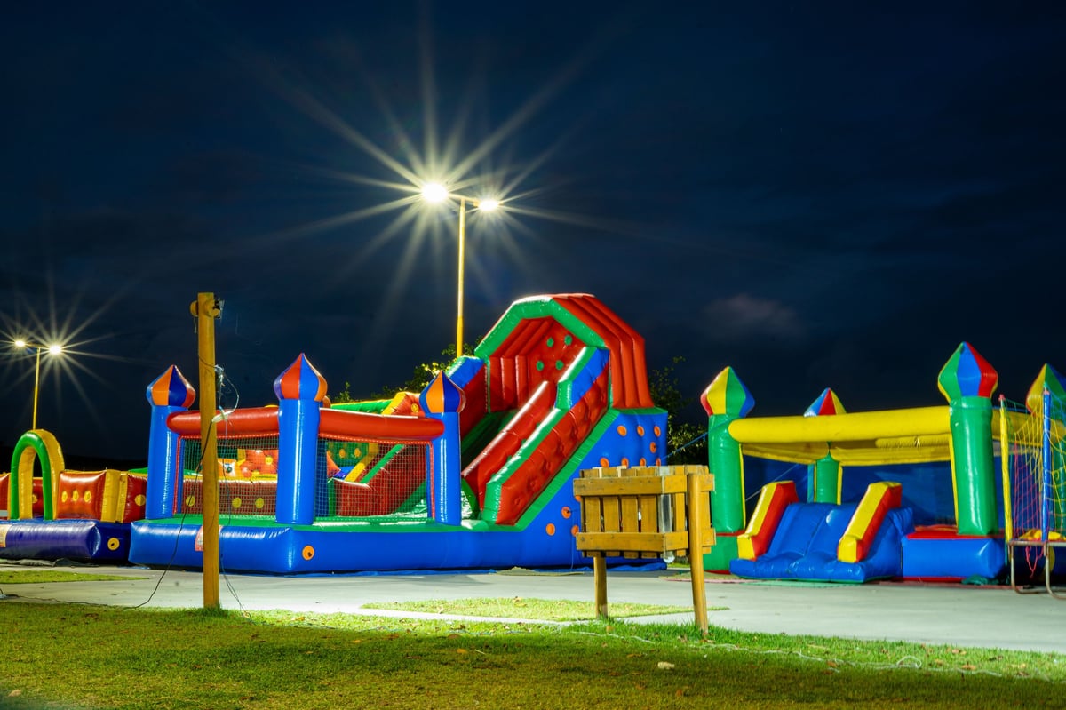 Colorful inflatable playground at night under bright streetlights